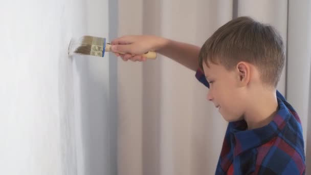 Dítě teen chlapec malování zeď pomocí štětce dělá renovaci doma ve svém pokoji. — Stock video