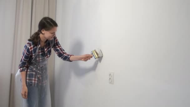 Живописец красит стены кистью, выполняя ремонт дома. — стоковое видео