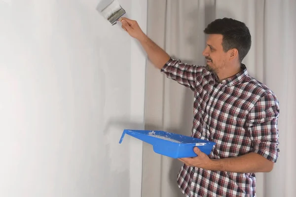 Mann Haus Maler bemalt Wand mit Pinsel Renovierung zu Hause, DIY. — Stockfoto