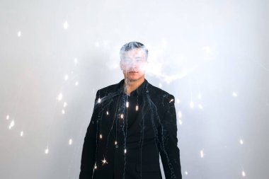 Sihirbaz gri arka plandaki şovunda parlak bir havai fişek yapıyor..