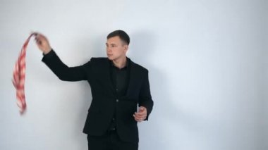 Siyah takım elbiseli sihirbaz türbandan metal çubuk yapıyor..