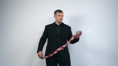Siyah takım elbiseli sihirbaz türbandan metal çubuk yapıyor..