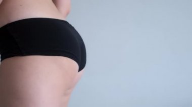 Selülit kalçalı kadın beyaz arka planda kalçaları için spor yapıyor..