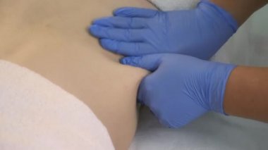 Doktor, karın bölgesine ozon gazı enjekte edildikten sonra kadına masaj yapıyor..