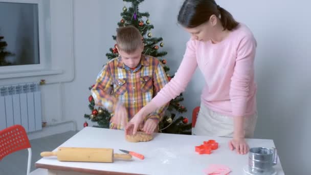 Mamá e hijo están haciendo masa de jengibre para galletas de Navidad juntos en casa. — Vídeo de stock