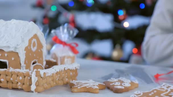 Woman is packaging gingerbread houses for Christmas, hands closeup. — Stock Video