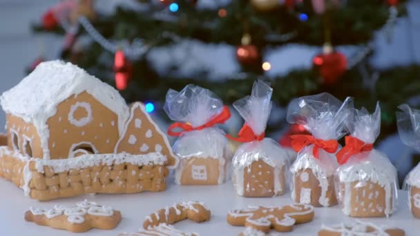 Gingerbread houses and cookies in package for Christmas on tree background. — Stock Video