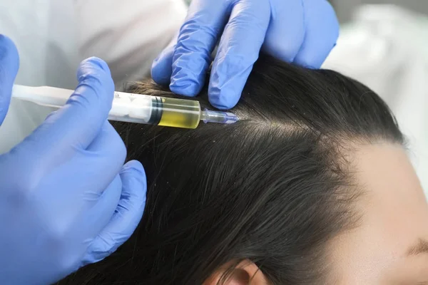 Doctor tricholoog maakt injecties in vrouwen huid op het hoofd voor haargroei. — Stockfoto
