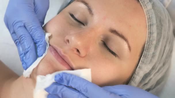Cosmetologist dokter menyeka wajah wanita menggunakan serbet antibakteri, pandangan atas. — Stok Video