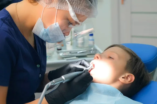 치과 의사가 십 대 소년의 치 과를 구강 위생적으로 청소하는 모습. — 스톡 사진
