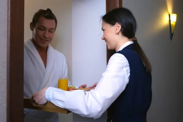 女性ホテル労働者のメイドは、客室に朝食トレイを運んでいる. — ストック写真