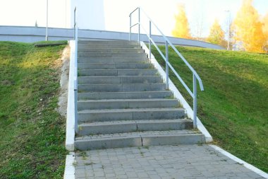 Parktaki merdivenler yeşil çimlerin arasında, şehrin altyapısı....