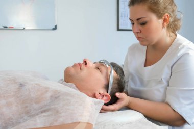 Kayropraktik uzmanı, migrenden dolayı kafasına elektronik saç bandı takıyor..