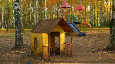 Sonbahar kenti parkında kaydırak ve küçük evi olan çocuklar için oyun alanı.
