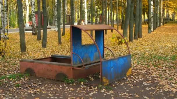 Tempat bermain umum untuk anak-anak dengan truk kayu di taman kota musim gugur. — Stok Video