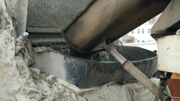 Beton wordt van een betonmenger in een container op de bouwplaats gegoten.. — Stockvideo