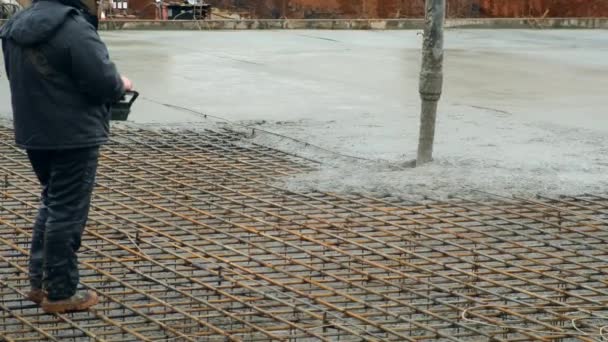 Man häller grunden våt tung betong genom röret med hjälp av fjärrkontroll. — Stockvideo