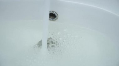 Lavabodaki kanalizasyon tıkanmış ve musluktan su dökülüyor..