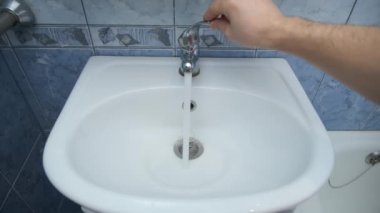 Adam lavabodaki suyu açar, ortasından dökülür..