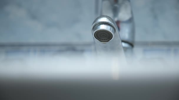 Goteo de agua de un grifo en el lavabo blanco en el baño, vista de cerca. — Vídeo de stock