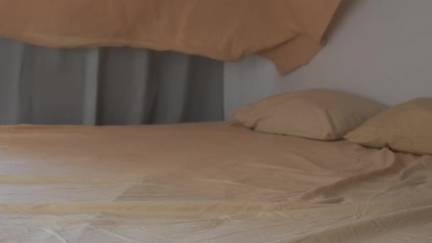 Persona rende il letto in camera da letto diffonde con attenzione il copripiumino sul letto — Video Stock