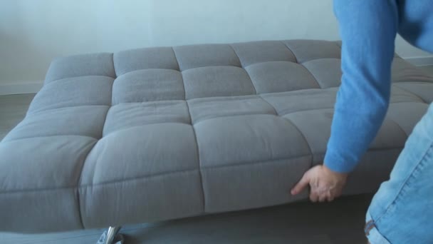 男人把毛毯和枕头叠起来放在沙发上，近距离观看. — 图库视频影像