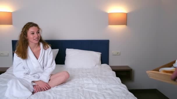 Man bracht ontbijt dienblad naar hotelkamer en plaatste het op bed naast vrouw. — Stockvideo