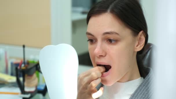 Woman in dentistry removes silicone teeth trainer from her mouth by herself. — Stock Video
