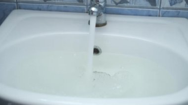 Lavabodaki kanalizasyon tıkanmış ve musluktan su dökülüyor..