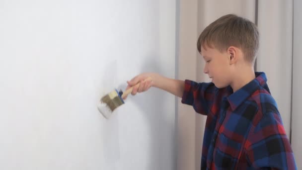 Kind tiener jongen schilderen muur met behulp van borstel doen renovatie thuis in zijn kamer. — Stockvideo