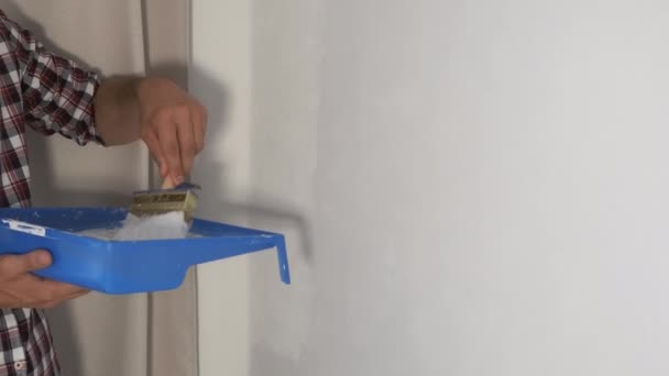 Mężczyzna dom malarz maluje ścianę za pomocą pędzla robi remont w domu, DIY. — Wideo stockowe