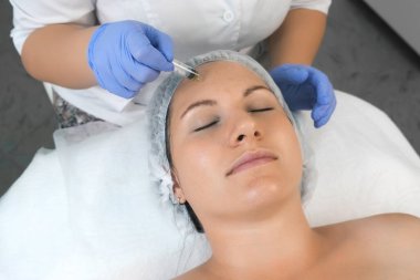 Kozmetik uzmanı, güzellik kliniğinde kadınların yüzüne sarı kabuk bağlıyor..