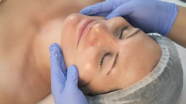 Medico cosmetologo che fa massaggio facciale mioplastico alla donna in clinica di bellezza. — Video Stock