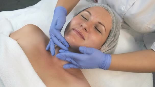 Kozmetik uzmanı kadın yüzüne nemlendirici krem sürüyor.. — Stok video