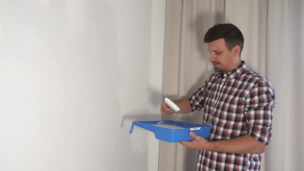 Man house painter is painting wall using brush doing renovation at home, DIY. — Stock Video