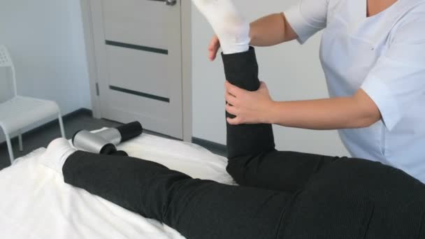 Osteopati doktoru, kanepede yatan kadına masaj yapıyor.. — Stok video