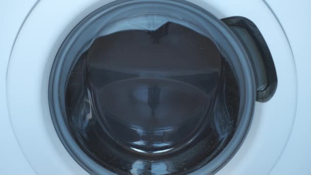 Wasmachine wikkelt de was grijs sprei, close-up venster. — Stockvideo
