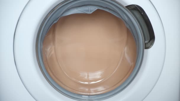 Machine à laver sèche le linge de lit beige blanchisserie, vue rapprochée sur la fenêtre. — Video