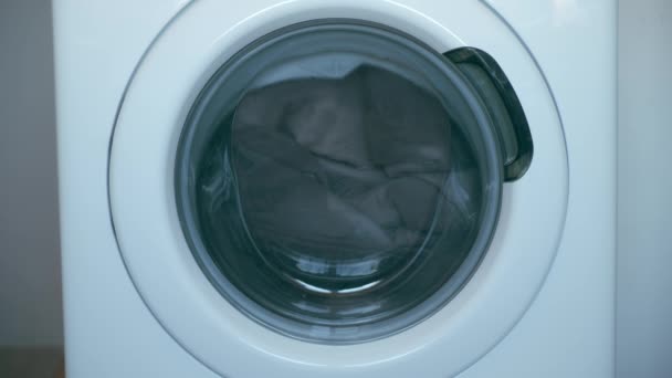 Machine à laver avec couvre-lit gris à l'intérieur fonctionne, buanderie à la maison. — Video