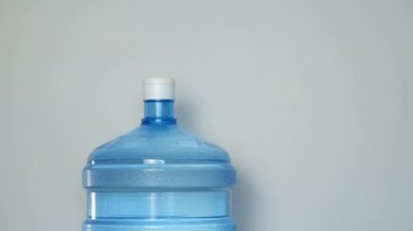 İnsan elleri su soğutucusundan bardağa su döker. Yakın çekim görüntüsü..