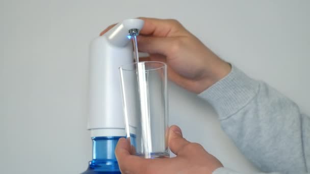 Mans mani versare acqua nel vetro da un dispositivo automatico di raffreddamento ad acqua, vista da vicino. — Video Stock