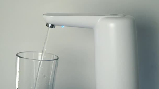 El agua clara se vierte en el vidrio desde un enfriador de agua automático, vista de primer plano. — Vídeos de Stock