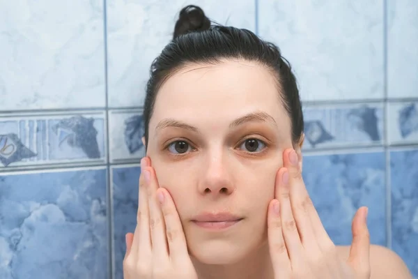 Mujer joven está aplicando ácido hialurónico en la piel de la cara tomando un baño con espuma. — Foto de Stock