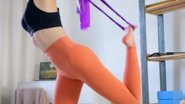 Genç bayan dans lordu pozu veriyor Natarajasana evde yoga yapıyor..