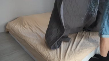 Adam yatak odasındaki yatağı dikkatlice ekose ya da battaniyeyi yatağa serer..