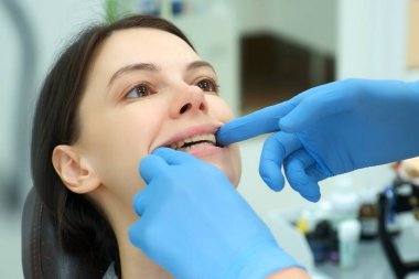 Ortodontist doktor kadın dişlerinin kapanmasını silikon eğitmenle kontrol ediyor..