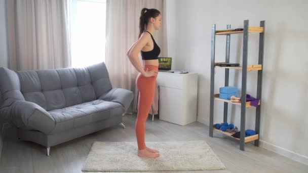 Junge Frau übt sich in Tanzpose Natarajasana beim Yoga zu Hause. — Stockvideo