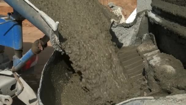 Betonöntés egy betonkeverőből fémtartályban az építkezés helyén. — Stock videók