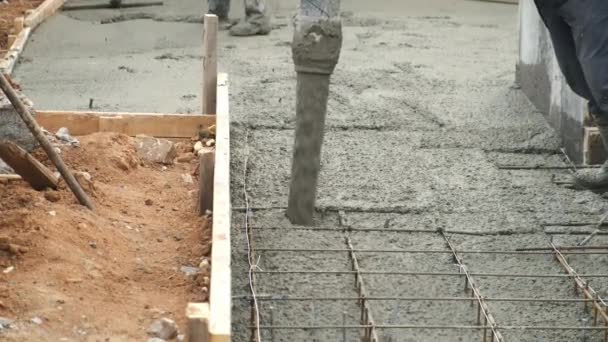 Homem está derramando fundação com concreto pesado molhado através da tubulação, vista close-up. — Vídeo de Stock