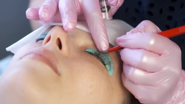 Cosmetologue flexion des cils avec aiguille dans les bigoudis, soulever les cils stratifié. — Video